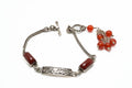 Silver bracelet with red beads on a white background