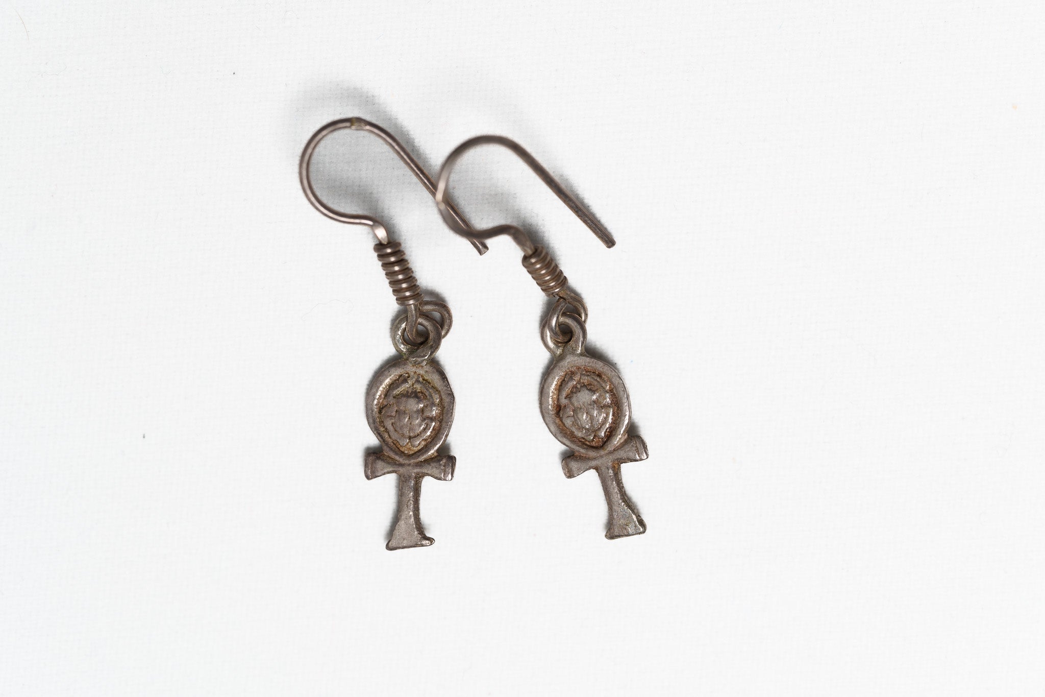Pair of silver Ankh earrings on a white background